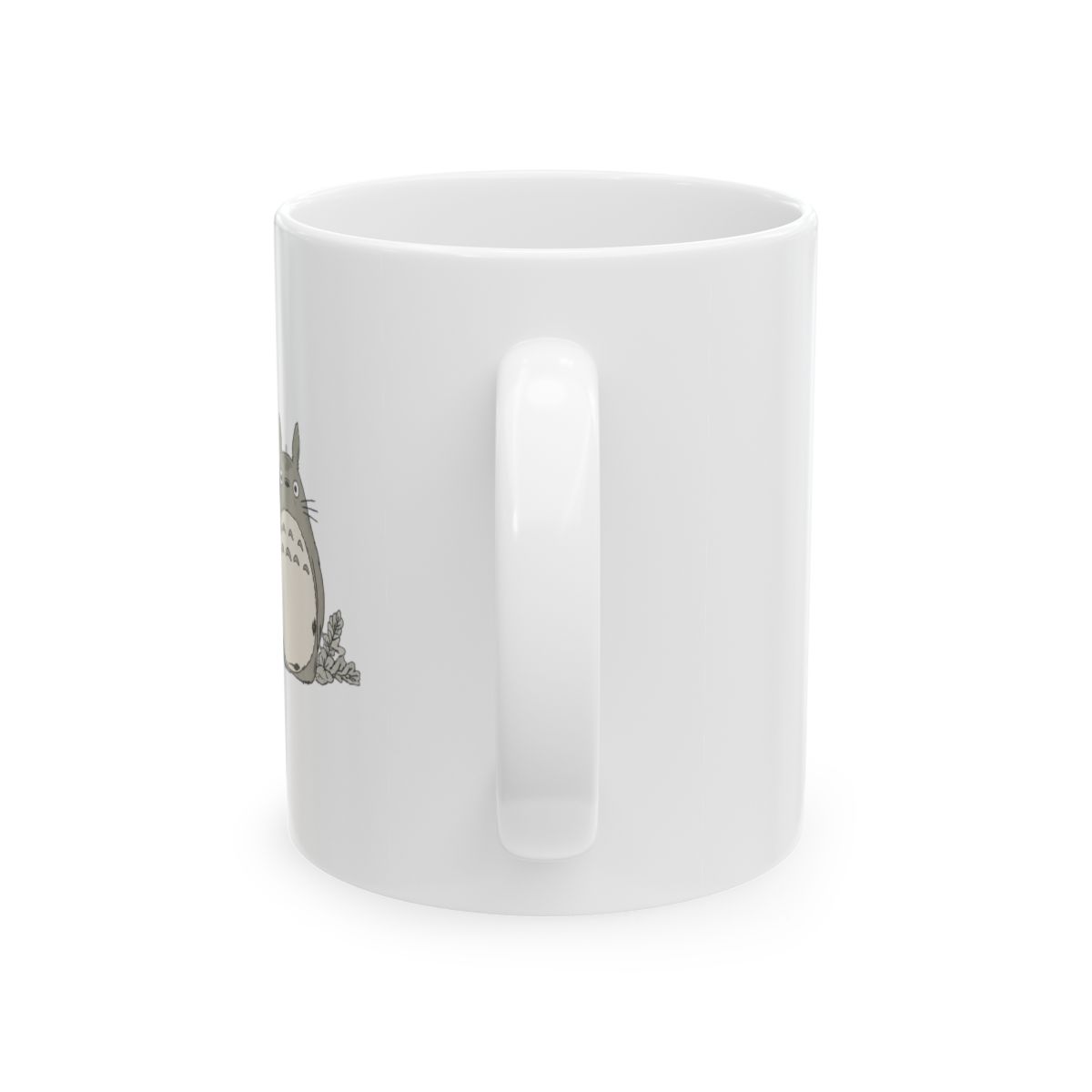 Black ceramic mug with a tan base and a black handle. The mug features a graphic of a character from the animated film "My Neighbour Totoro" with a rainy scene. The mug is on a neutral surface - alternate angle 3, merchandise